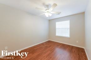 Houston house for rent - a bedroom with wood flooring and a ceiling fan