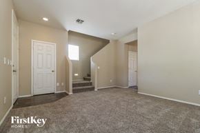 Surprise house for rent - an empty living room with two doors and a carpeted staircase