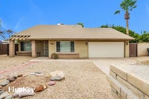 Phoenix house for rent - A house with a driveway and a palm tree in the background.
