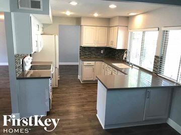 Phoenix house for rent - a kitchen with white cabinets and a large counter top