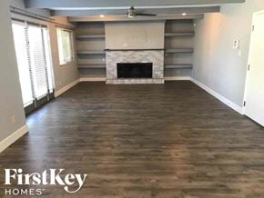 Phoenix house for rent - an empty living room with wood floors and a fireplace