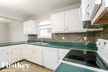 Noblesville house for rent - A kitchen with white cabinets and a green countertop.