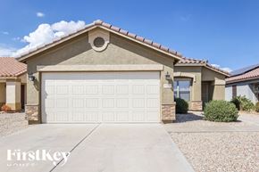 Surprise house for rent - A house with a garage door in the foreground and a clear blue sky above.