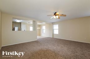 Surprise house for rent - A spacious room with a ceiling fan and carpeted floor.