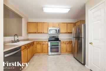 Surprise house for rent - A kitchen with wooden cabinets and stainless steel appliances.