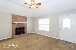 Cordova house for rent - a living room with a brick fireplace and a ceiling fan
