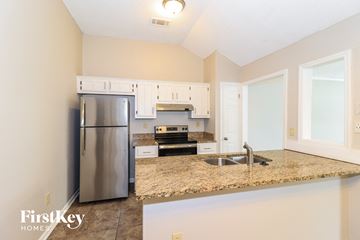 Cordova house for rent - a kitchen with granite counter tops and a stainless steel refrigerator