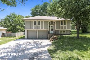 Belton house for rent - a tan house with a driveway and trees