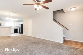 Houston house for rent - A spacious living room with a carpeted floor and a ceiling fan.
