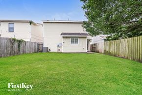 Houston house for rent - A grassy backyard with a fence and a house in the background.