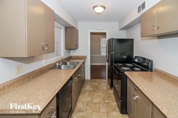 Memphis house for rent - a kitchen with a black stove and a black refrigerator