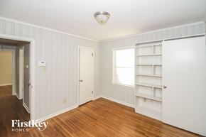 Memphis house for rent - a bedroom with white walls and wood floors and a white book shelf