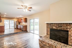 Jacksonville house for rent - a living room with a fireplace and a kitchen with a sliding glass door