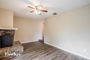 Jacksonville house for rent - a living room with a fireplace and a ceiling fan
