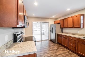 Jacksonville house for rent - a kitchen with wooden cabinets and a stainless steel refrigerator