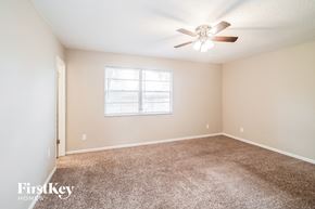 Jacksonville house for rent - a bedroom with carpet and a ceiling fan
