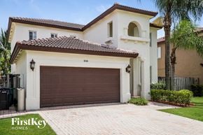 Miami house for rent - A house with a brown garage door is for sale.