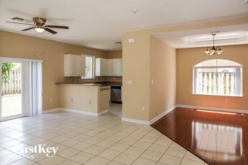 Miami house for rent - A spacious room with a kitchen area and a dining table.