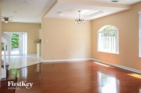 Miami house for rent - A spacious room with wooden floors and a chandelier.