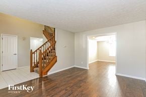 Brownsburg house for rent - A spacious room with a wooden staircase and white walls.