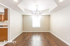 Brownsburg house for rent - A large empty room with wooden floors and a chandelier.