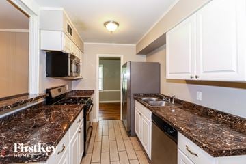 Memphis house for rent - a kitchen with granite counter tops and white cabinets