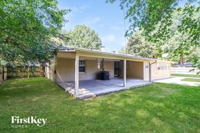 Memphis house for rent - a small tan house with a porch and a grassy yard