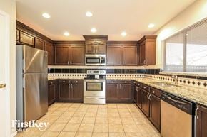 Surprise house for rent - a kitchen with wooden cabinets and stainless steel appliances