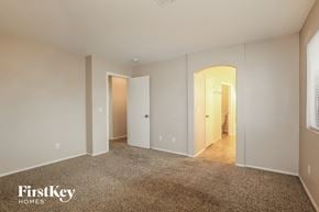 Surprise house for rent - a master bedroom with a carpeted floor and white walls