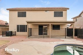 Surprise house for rent - a house with a pool and a fence in front of it