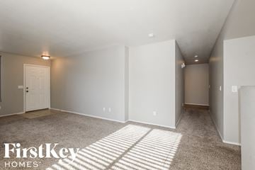 Surprise house for rent - the living room and dining room with white walls and carpet