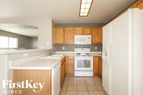 Surprise house for rent - a kitchen with white appliances and wooden cabinets