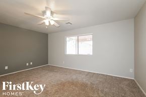 Surprise house for rent - a bedroom with a ceiling fan and a window