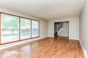 South Holland house for rent - A spacious room with wooden floors and a staircase.