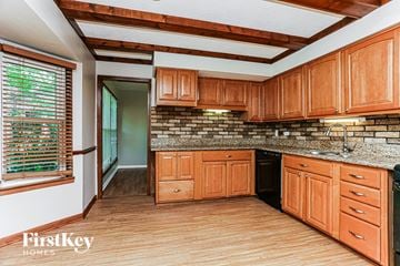 South Holland house for rent - A kitchen with wooden cabinets and a brick backsplash.