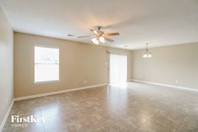 Cypress house for rent - an empty living room with a ceiling fan and tiled floor