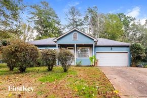 Cumming house for rent - a blue house with a driveway and a garage door