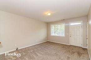 Cumming house for rent - the master bedroom is spacious and clean with carpeted flooring and a white door