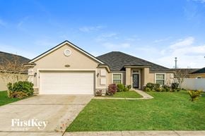 Jacksonville house for rent - a beige house with a garage and a lawn