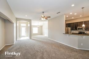 Jacksonville house for rent - an empty living room with a ceiling fan and a kitchen
