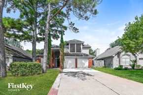 Houston house for rent - a white house with a driveway and a garage door