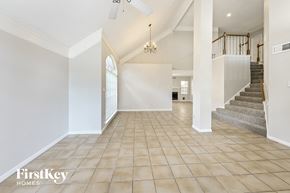 Houston house for rent - a large living room with a staircase and a tile floor