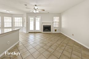Houston house for rent - an empty living room with a fireplace and a ceiling fan