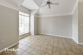 Houston house for rent - an empty living room with a ceiling fan and a window