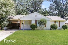 Memphis house for rent - A white house with a porch and a tree in front.