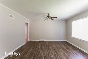 Memphis house for rent - A room with a ceiling fan and wooden flooring.