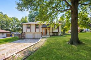 Independence house for rent - a white house with a large tree in front of it