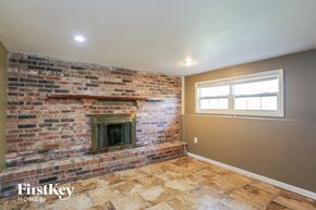 Independence house for rent - the living room has a brick fireplace and a window