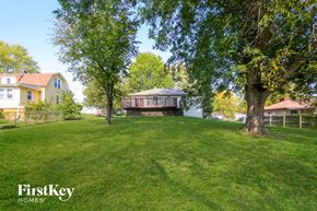 Independence house for rent - a backyard with a house and a large lawn and trees