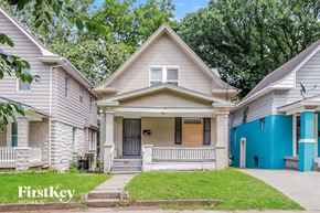 Kansas City house for rent - a white and blue house with a porch and a sidewalk
